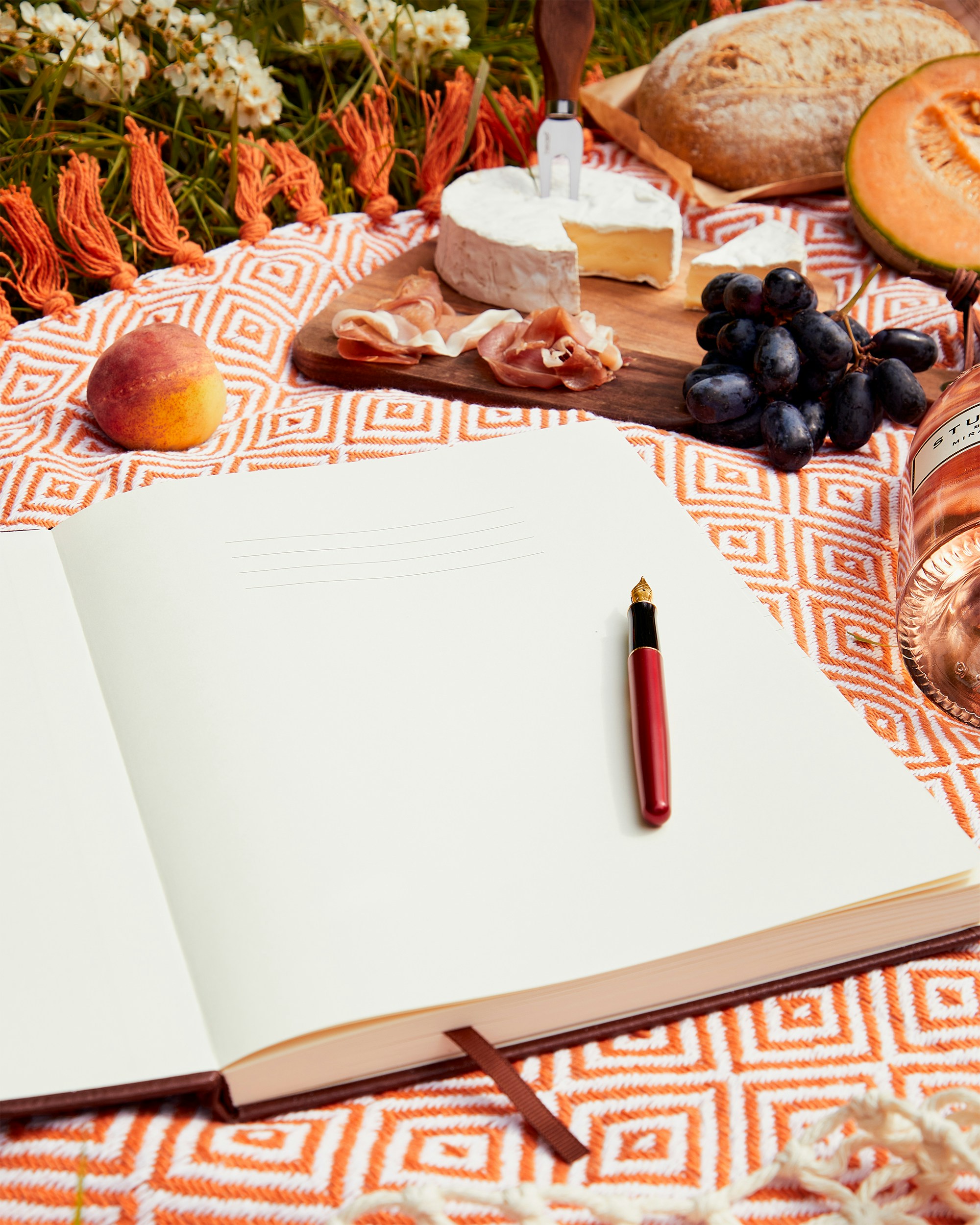 Will Write For Food. A Journal on a table piled with delicious food. Image by Beechmore Books via Upsplash.