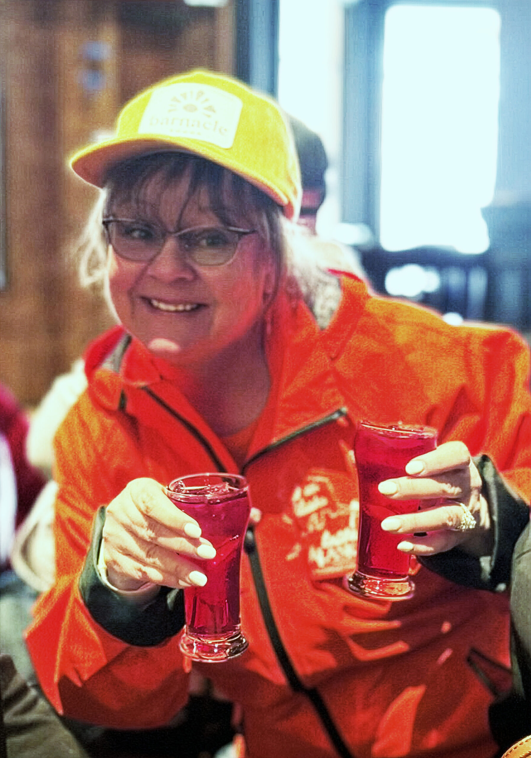 Chief Eating Officer, Midgi Moore holding two beers at the Crystal Saloon
